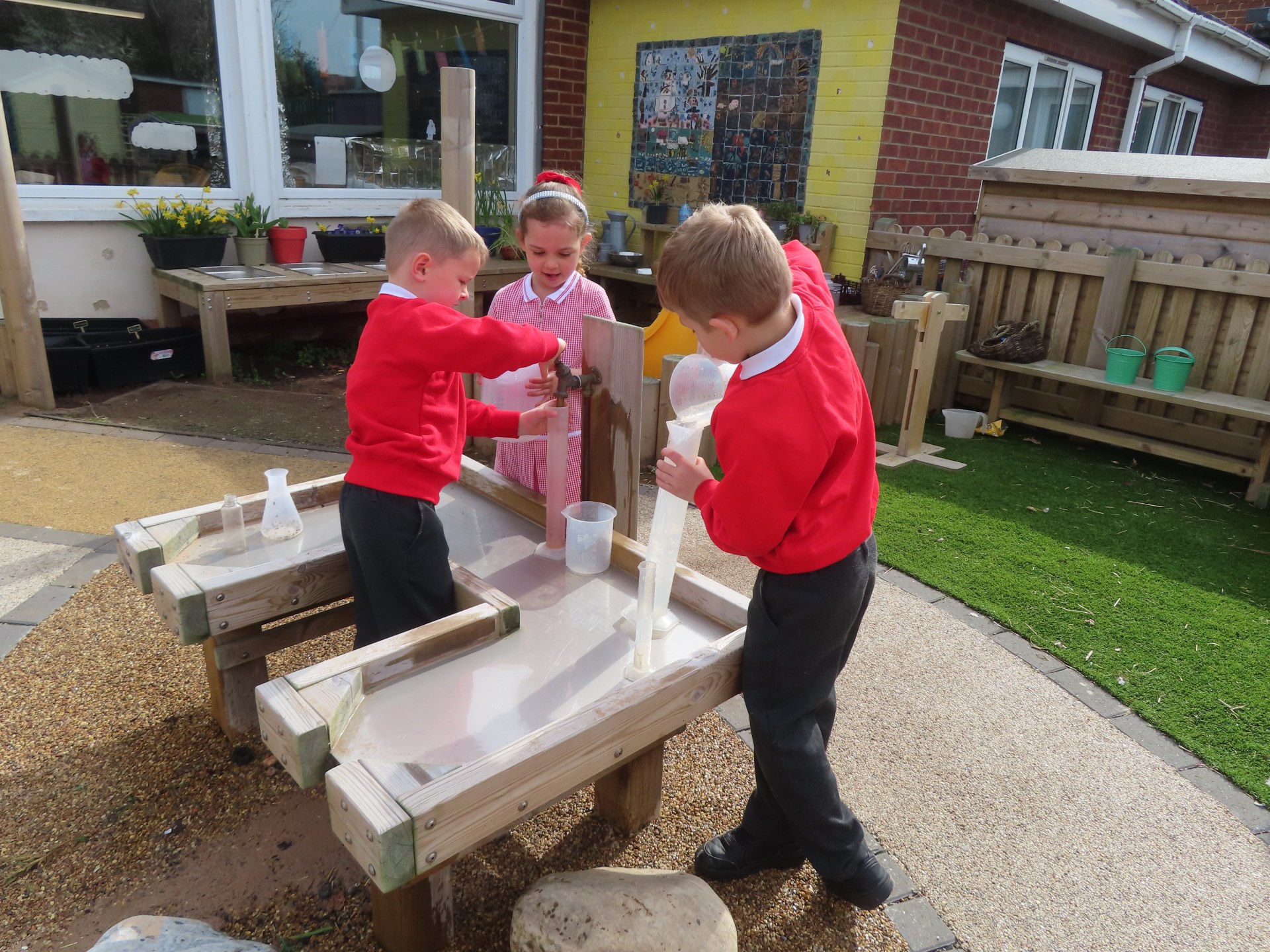 children pouring water in tubes